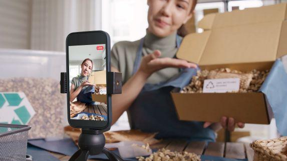 Live-Video mit Smartphone: Creator zeigt Produkt-Unboxing – Content Creation, Social Ads, Community-Management und Reporting.