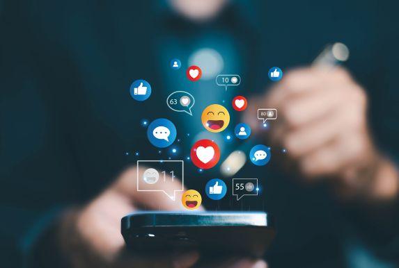 Smartphone mit Social-Media-Icons – Social Media Engagement für planbare Reichweite, qualifizierte Interaktionen und transparentes Reporting.