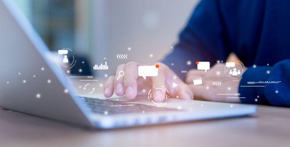 Hand tippt auf Laptop – Social-Media-Marketing mit planbarer Reichweite, mehr Interaktionen und transparentem Reporting.